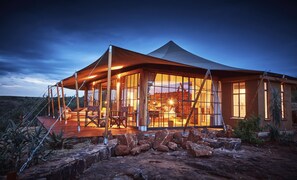 A spacious, well-lit tent with a large open area and a dining setup inside. - Elewana Loisaba Lodo Springs (Loisaba)