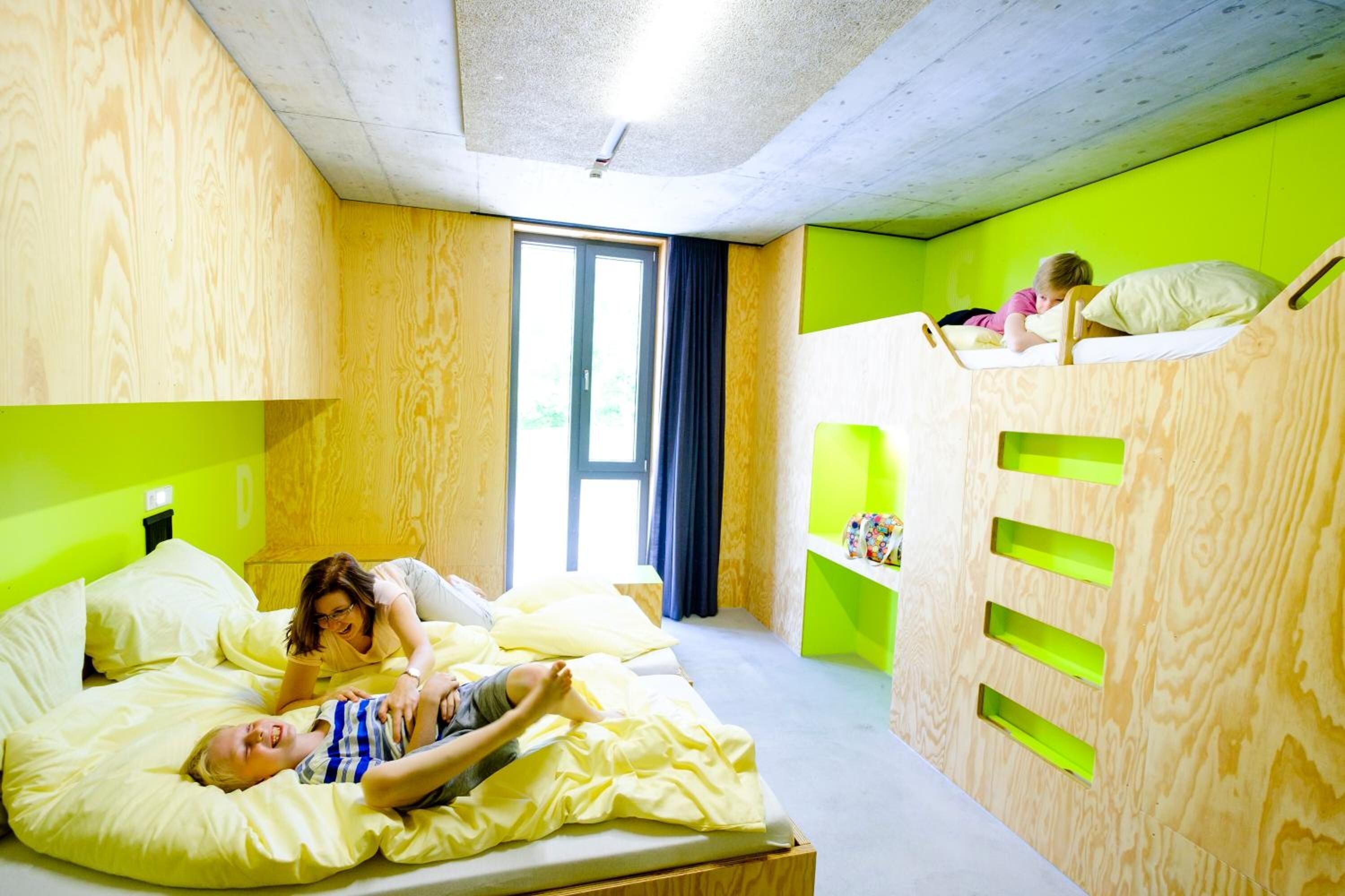 Ein Zimmer mit einem Bett, einem Etagenbett und einem Fenster.