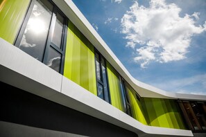 A modern building with large windows and a curved facade. - DJH Jugendherberge Bayreuth - Hostel (Bayreuth)