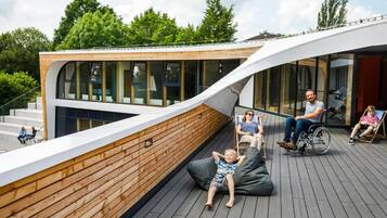 Un edificio moderno con techo curvo, paneles de madera y ventanas grandes.