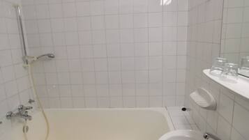 Ein Badezimmer mit einer Badewanne, einem Waschbecken und einer Dusche.