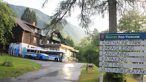 A hostel sign with amenities including adrenaline park, canyoning, kayaking, rafting, and bike/kayak rental.
