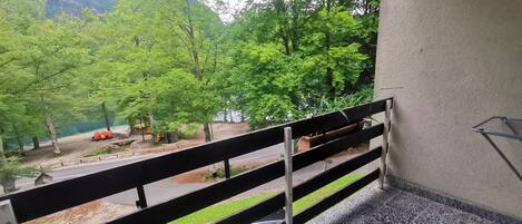 Un balcon donnant sur un parc et un lac.