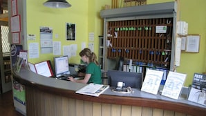A reception desk with computers, a bulletin board, and a key rack.