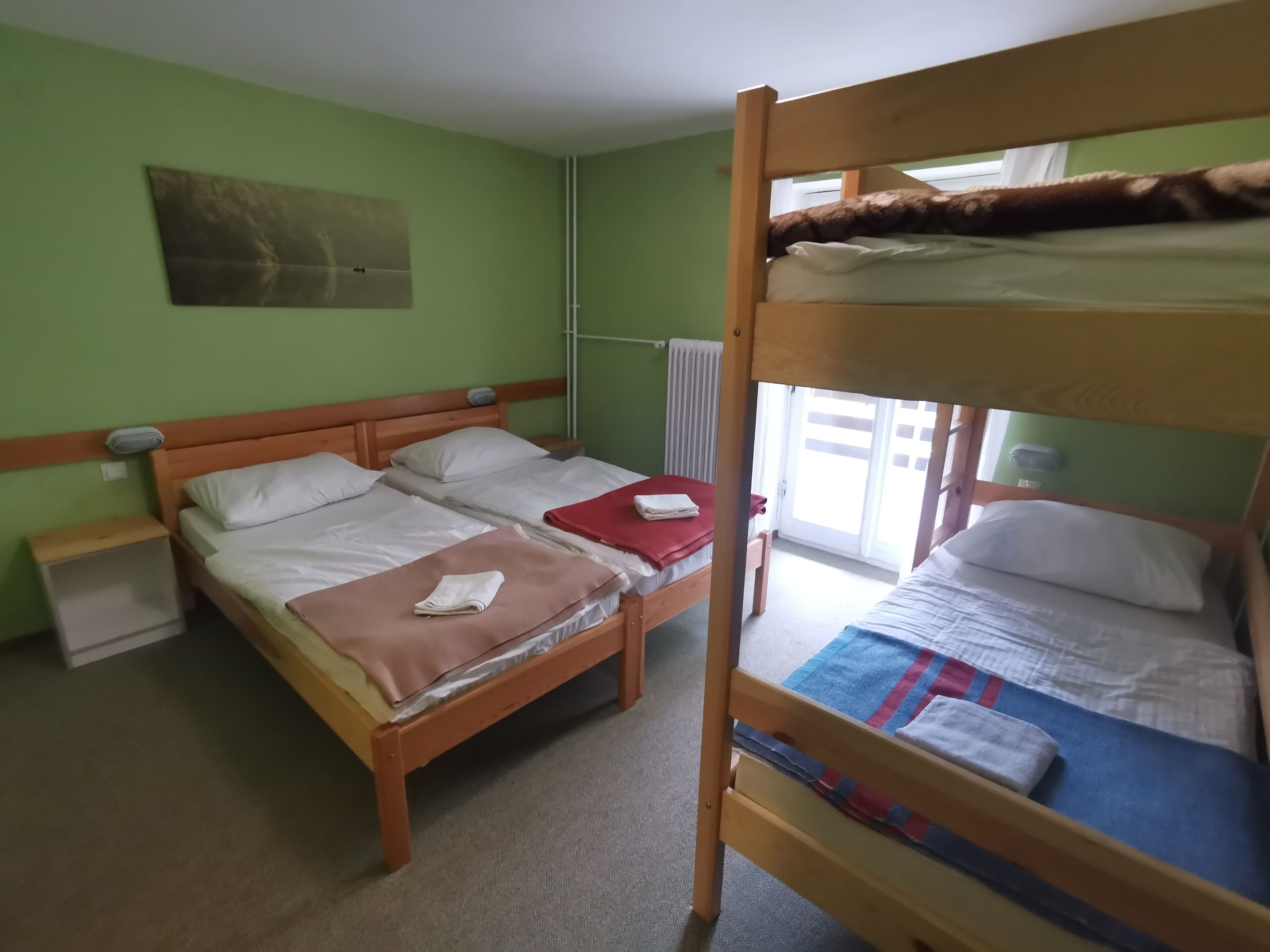 Habitación con literas, un mesita de noche y una estantería de pared.