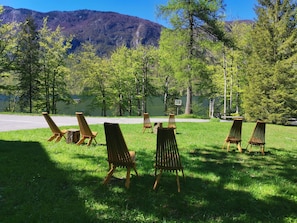Outdoor seating with a view of a lake and mountains. - Hostel pod Voglom (Bohinj)