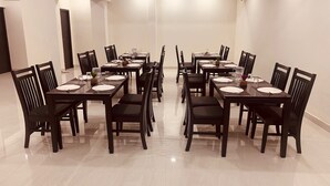Une salle de conférence dotée de plusieurs tables et de chaises, ainsi que de plaques nominatives et de sets de table.
