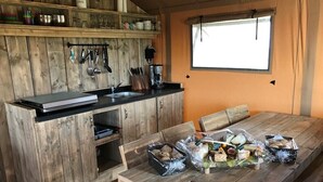 Cocina rústica con armarios de madera, un lavamanos y una mesa de comedor con comida.