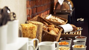 Un bufé de desayuno con panes, bollería y diferentes mermeladas y acompañamientos.