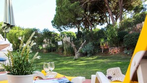 An outdoor dining area with a table set for two, a potted plant, and a menu. - Casa Moura Golfe | 3 Bedrooms | Vilamoura (Vilamoura)