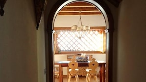 Un pasillo que conduce a un comedor con una mesa y sillas de madera.