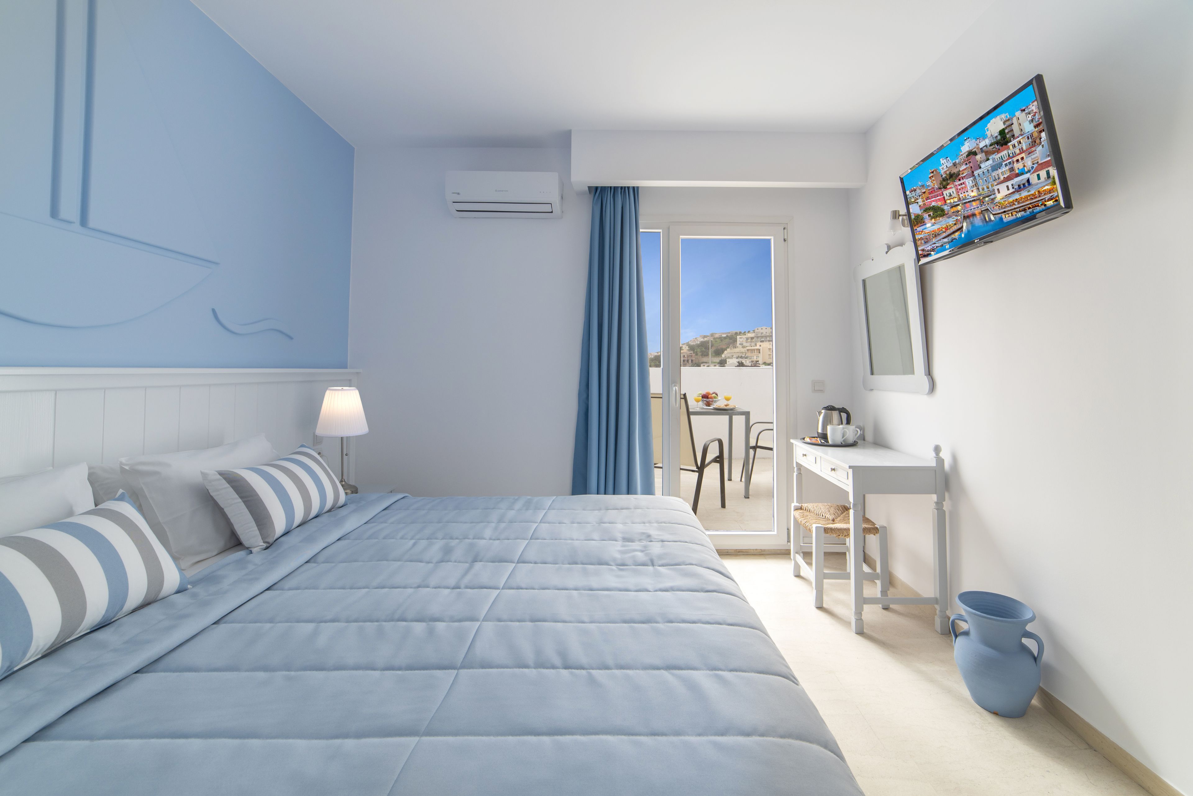 Camera d'hotel moderna con un letto, una scrivania e vista sulla città.