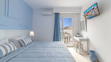 A modern hotel room with a bed, a desk, and a view of the city.