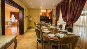 Un comedor con una mesa redonda dispuesta para seis personas, rodeada de sillas.
