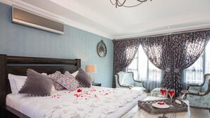 Un dormitorio con una cama grande, una mesita de noche con una bandeja de comida y bebidas, y una silla.