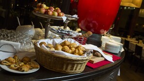 A buffet table with various food items including pastries, fruits, and condiments. - Hotel Belair (Wallisellen)
