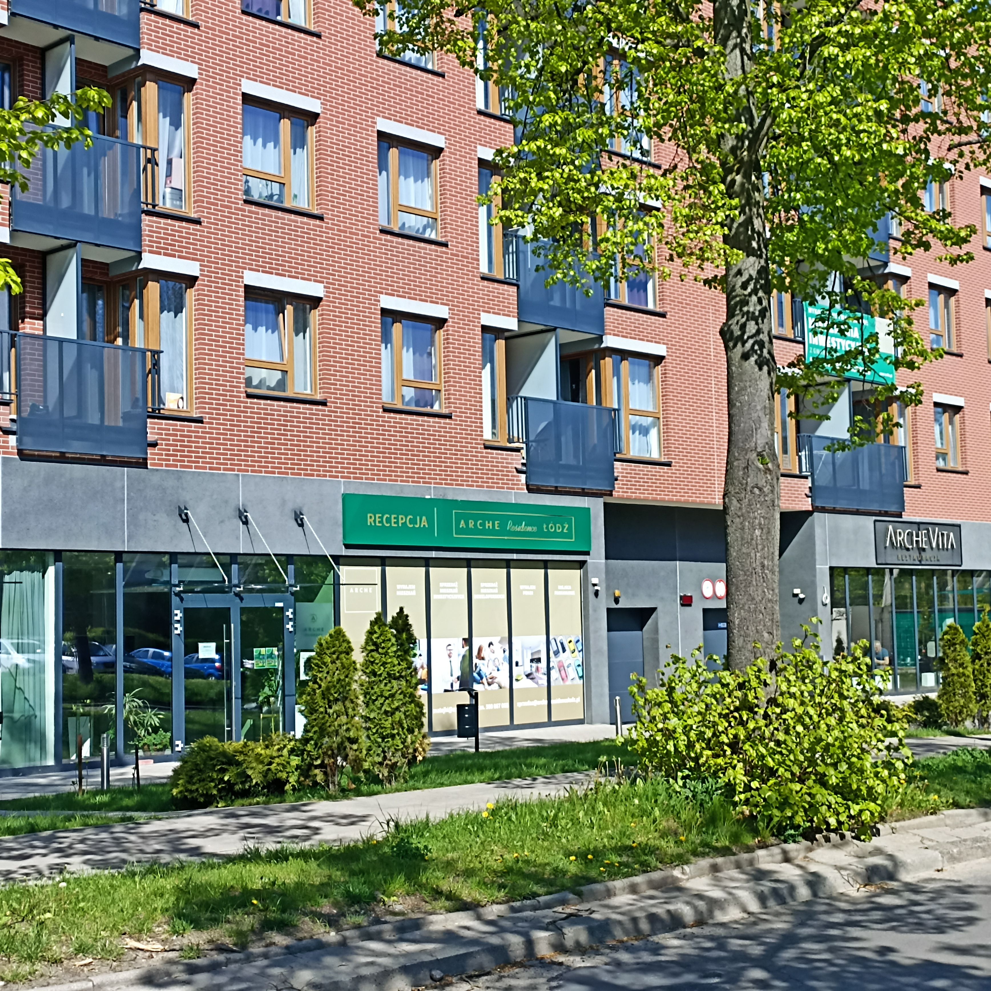 A multi-story building with a modern facade, featuring a reception area and a storefront with signage.