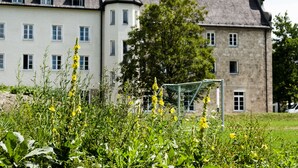 Een historisch gebouw met veel ramen en een gevel van natuursteen.
