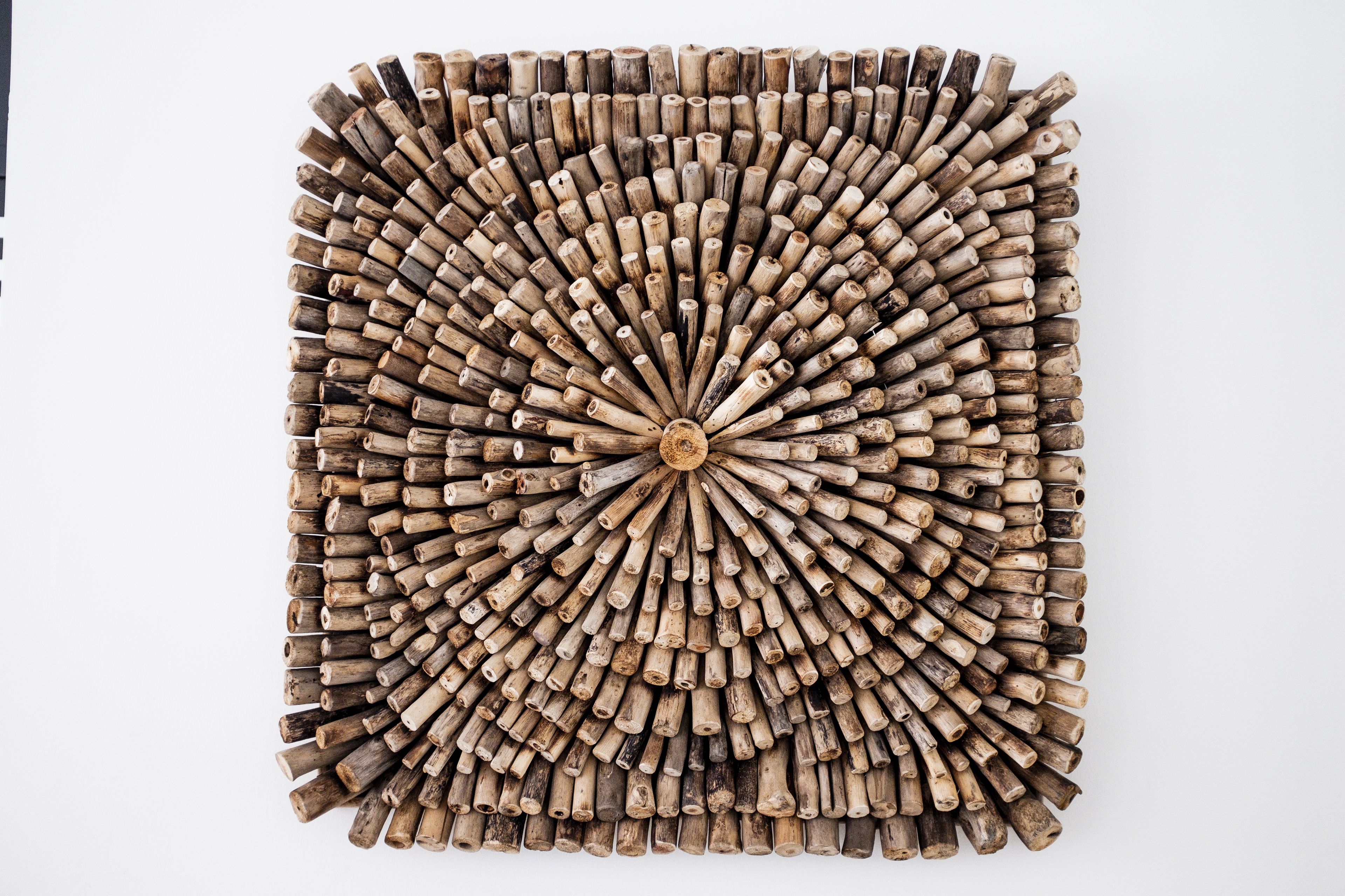 A square arrangement of cylindrical wooden objects.
