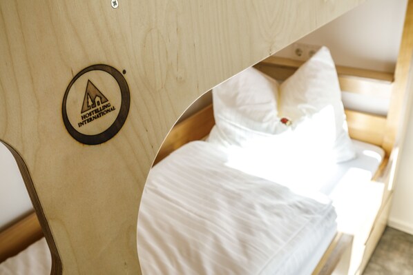 A wooden bunk bed with a logo for Hostelling International.