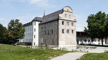 A historic building with a stone facade, multiple windows, and a central entrance.