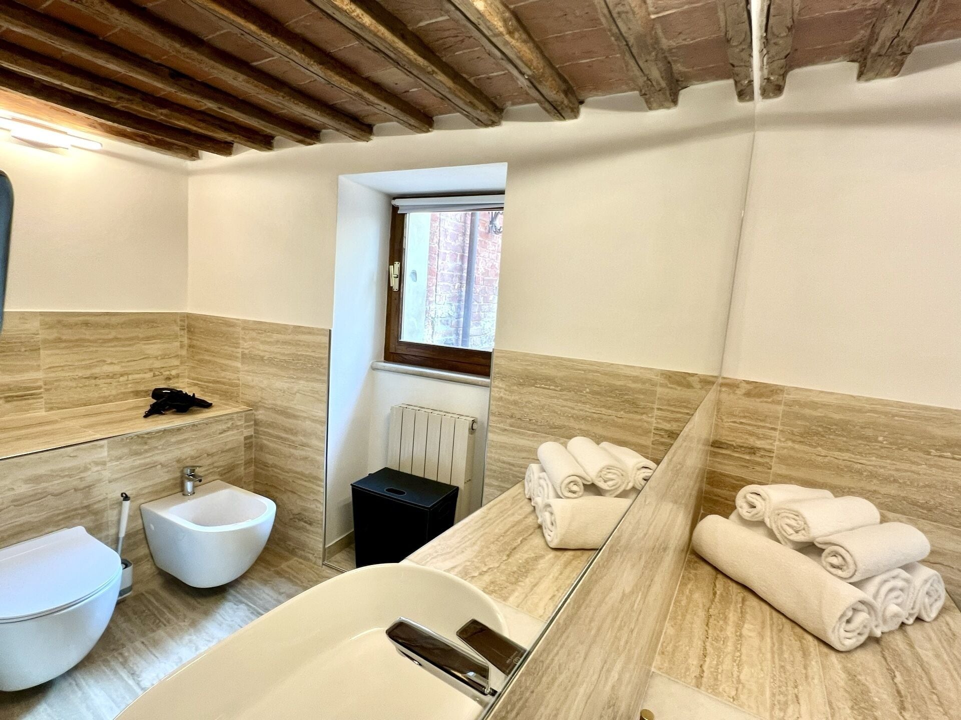 Un bagno con vasca, bidet, lavandino e asciugamani.