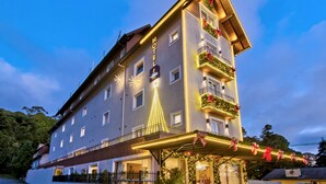 A hotel with a prominent tower-like structure, multiple balconies, and a well-lit facade. - Hotel Fioreze Primo (Gramado)
