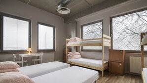 Une chambre de dortoir avec des lits superposés, un bureau et une chaise.