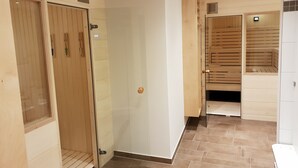 A hotel room with a wooden wardrobe, a glass door, and a tiled floor. - Hotel Clemenswerther Hof (Sögel)
