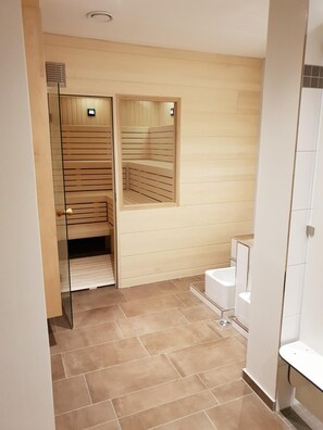 A modern bathroom with a glass shower enclosure, a toilet, and a sink. - Hotel Clemenswerther Hof (Sögel)