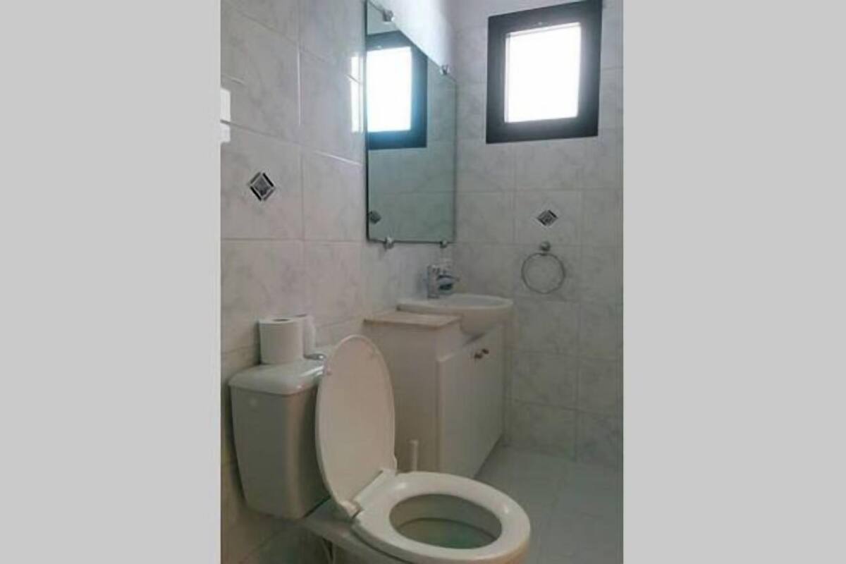Un baño pequeño y limpio con inodoro, lavamanos y espejo.