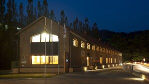 A large brick building with multiple windows and a prominent entrance. - Alberg Rural Ruta del Ferro (Sant Joan de Les Abadesses)