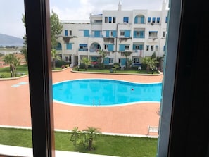 Piscine extérieure en saison, parasols
