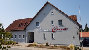 Un edificio con un letrero que dice 'Pension Cora' en la fachada.
