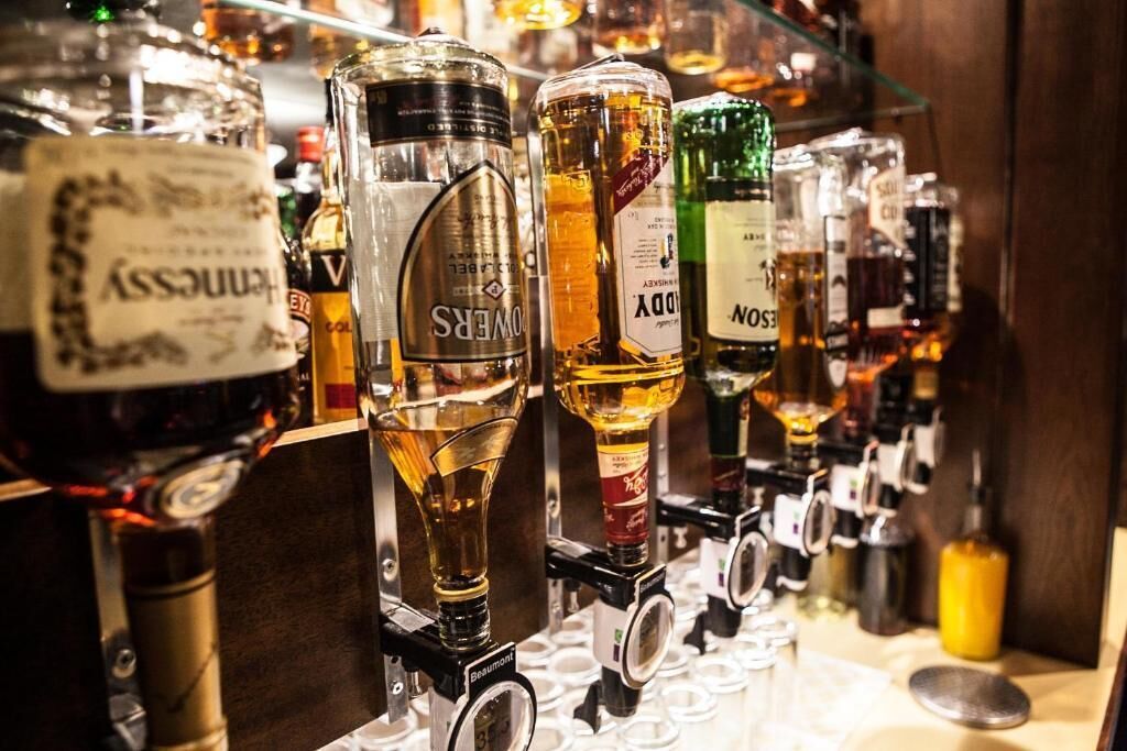 Eine Bar mit verschiedenen Spirituosenflaschen und einem Weinkühler.