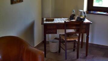 A room with a leather chair, a wooden desk, and a stone wall decoration.
