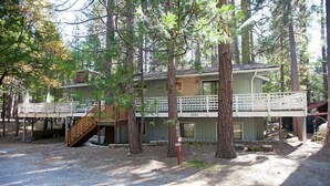 A two-story cabin with a deck, surrounded by trees. - The Tree House II (Yosemite National Park)