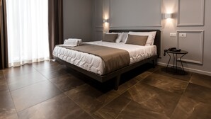 Una habitación de hotel moderna con una cama grande, dos mesitas de noche y una mesilla.
