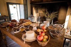 Un bufé de desayuno con diferentes alimentos y una chimenea al fondo.