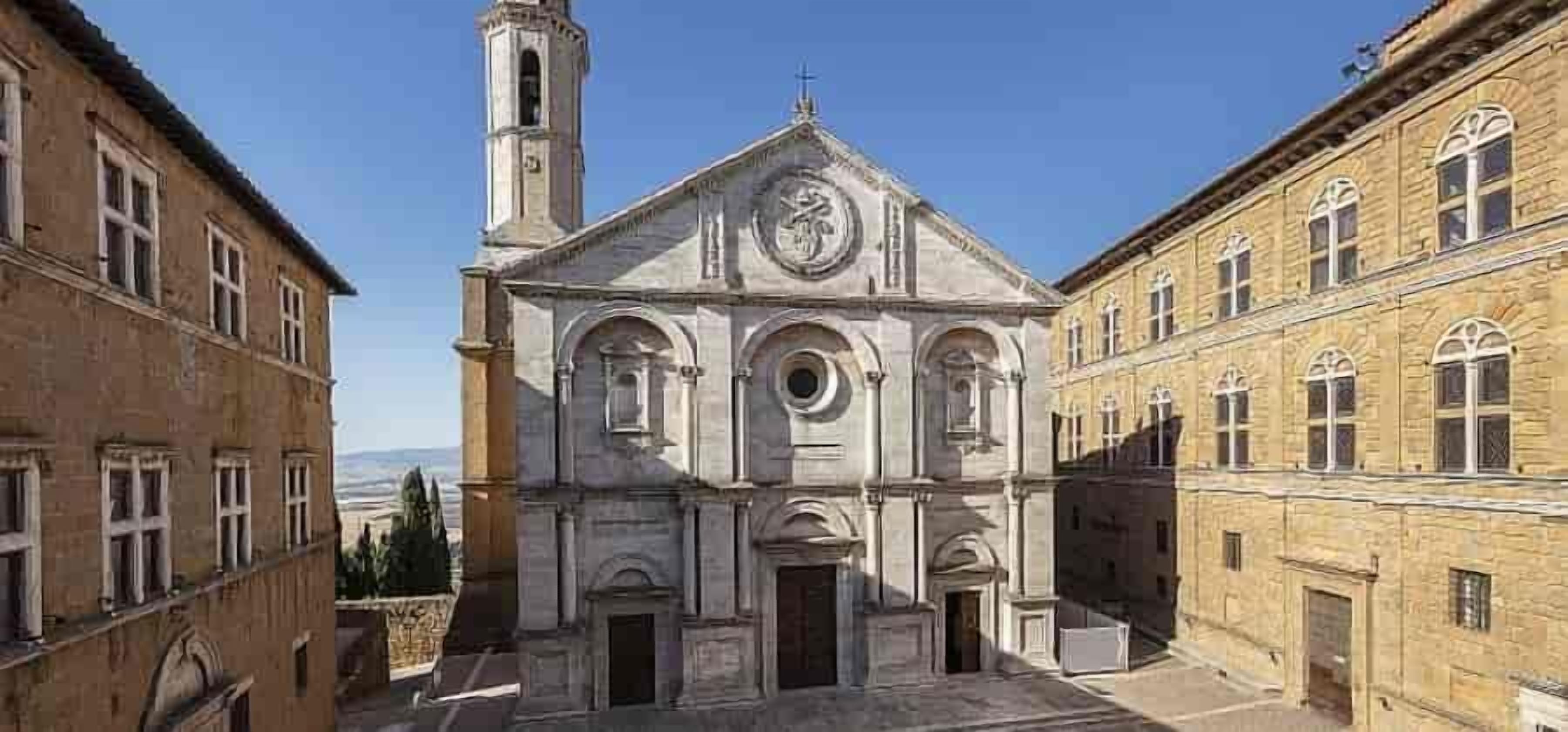Una iglesia histórica con una torre de campanas, ventanas de arco y una cúpula central.