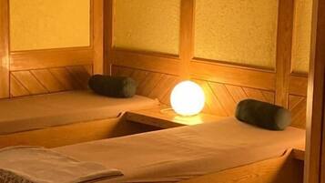 Una habitación con dos camas de madera, cada una con almohada y manta.