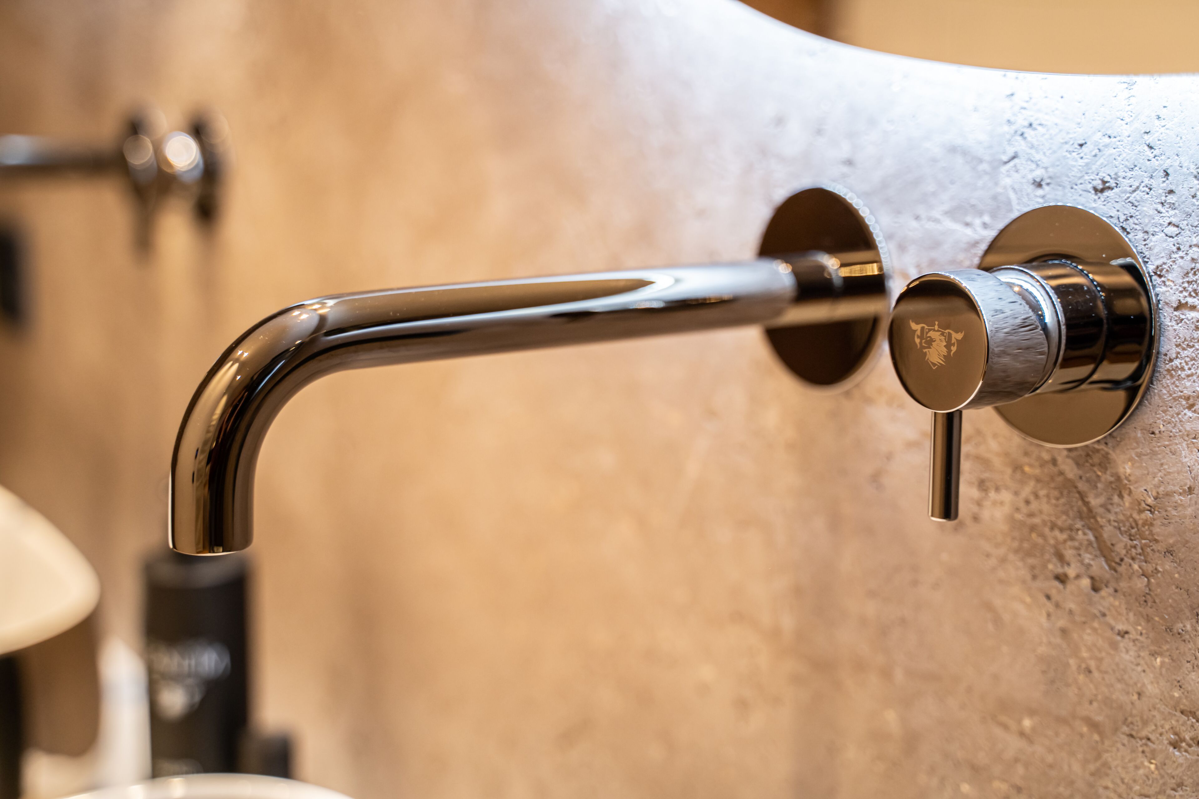 A bathroom sink with a chrome faucet and a soap dispenser.