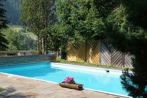 Una piscina al aire libre de temporada, sombrillas