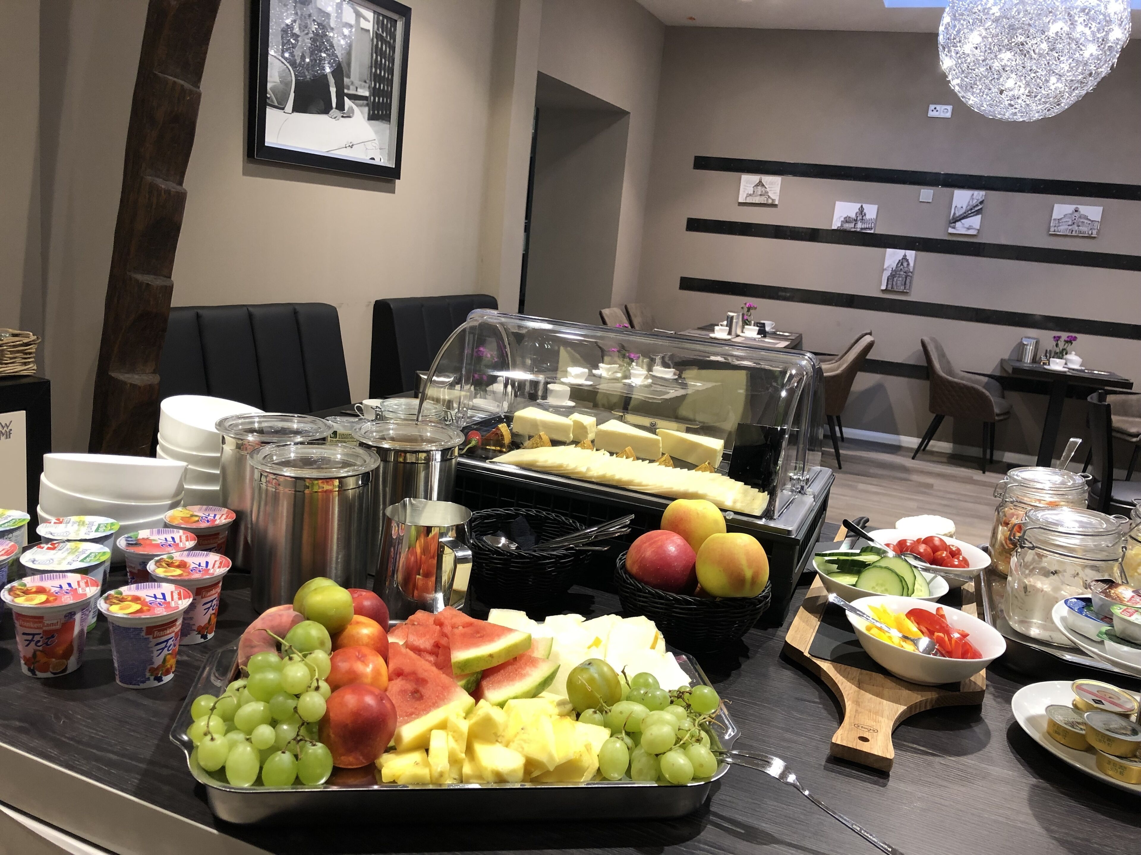 Una barra de desayuno con frutas variadas, yogur y quesos.