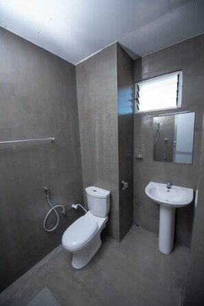 Un baño moderno con inodoro, lavabo y ducha.