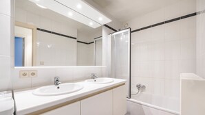 A modern bathroom with two sinks, a large mirror, and a glass-enclosed shower. - Pablo II-301 (Koksijde)