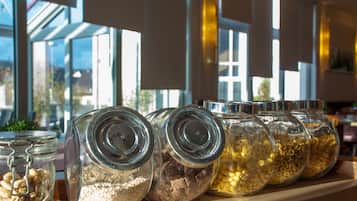 A shelf with glass jars containing various grains and seeds.