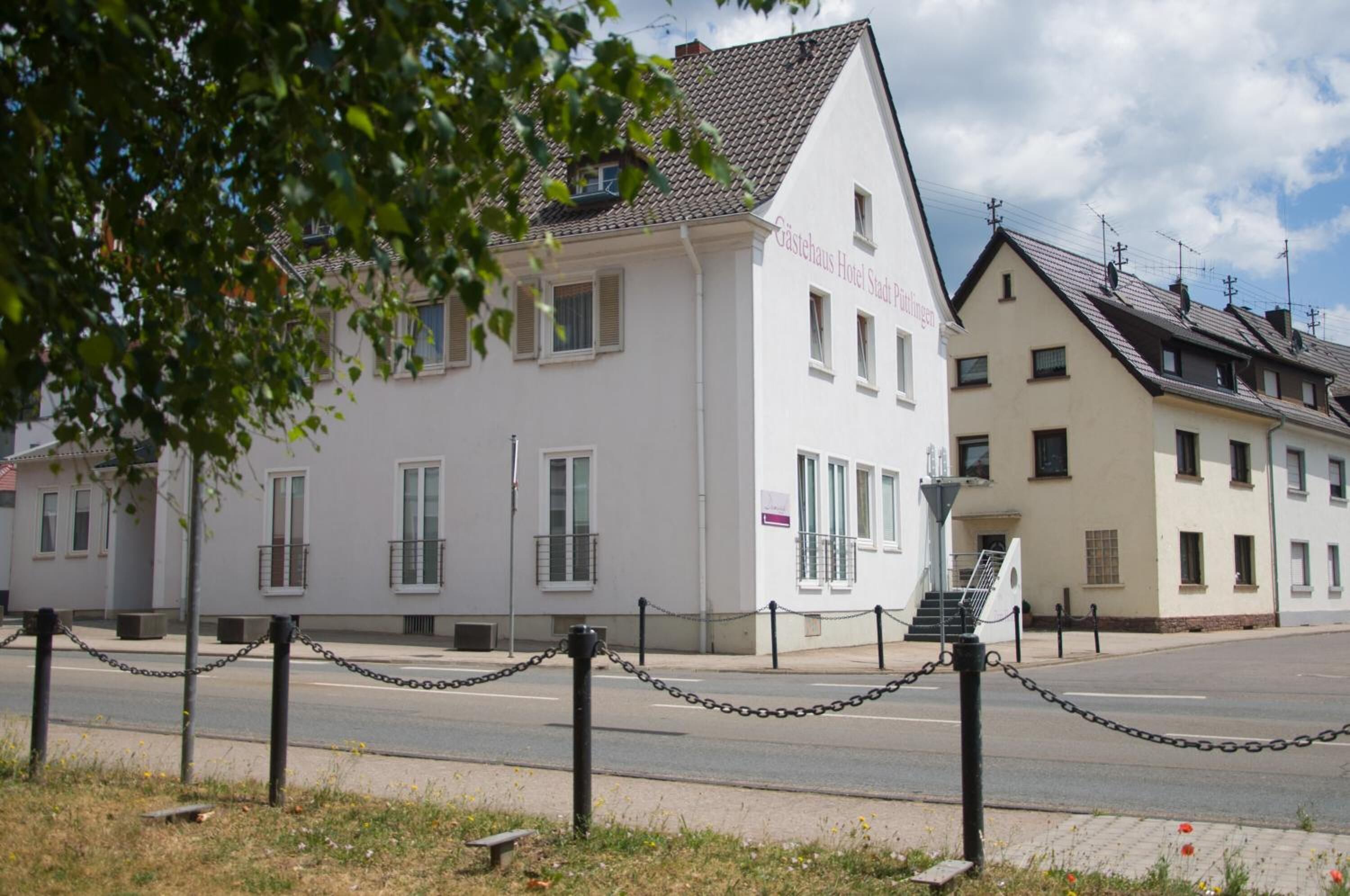 Un bâtiment blanc avec une enseigne indiquant « Gästehaus Hotel Stad Pfullingen ».