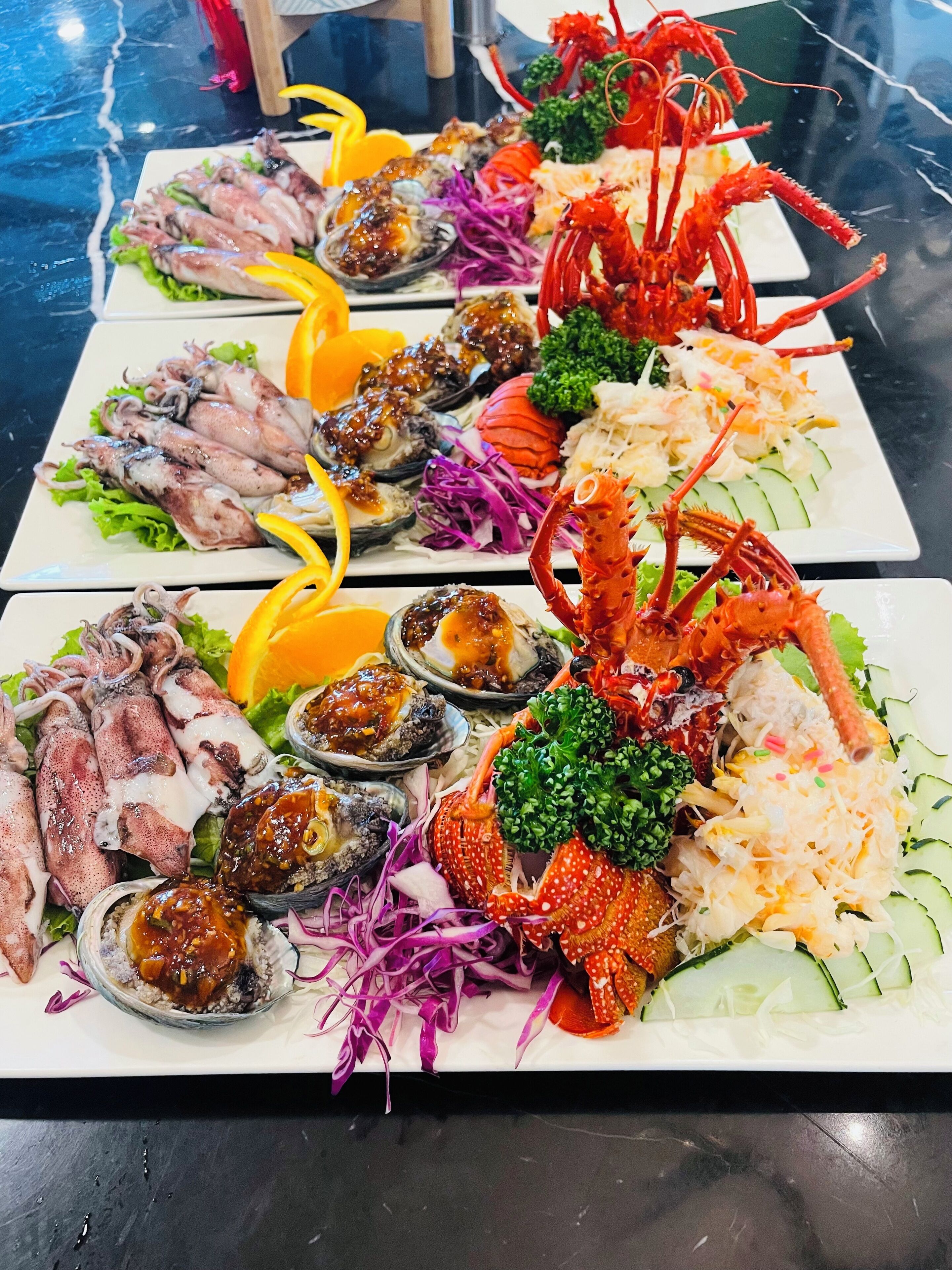 Un plateau de fruits de mer comprenant divers éléments, notamment des calamars, des huîtres et des pinces de crabe.