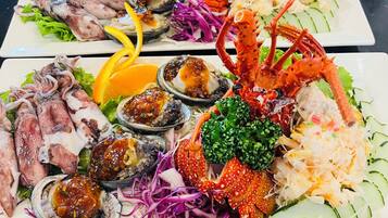 Un plateau de fruits de mer comprenant divers éléments, notamment des calamars, des huîtres et des pinces de crabe.